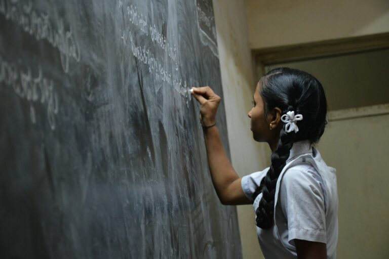 woman standing writing on black chalkboard